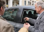 Remise des clés d'une voiture entre un propriétaire et un locataire dans une rue de ville
