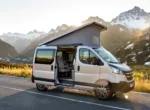 Van aménagé garé sur une route de montagne au coucher du soleil